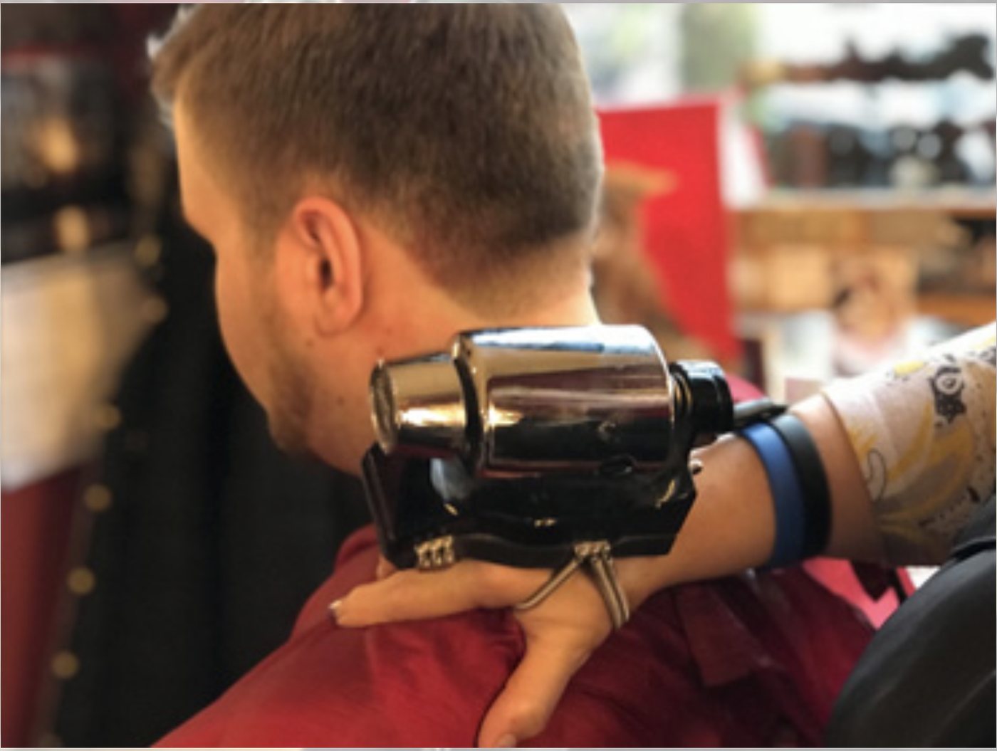 A barber cleaning up a customer's neckline with clippers